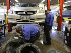 Staff switch a vehicle over to winter tires at the KAL Tire location on Pembina Highway in Winnipeg, Man., on Sat., Nov. 21, 2015.