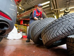 Charles Emsley from Island Park Esso in Ottawa balances and installs winter tires, Nov. 18, 2014.