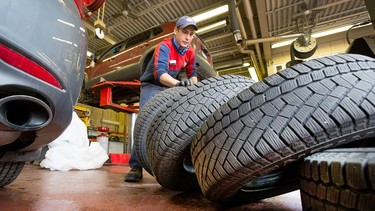 Charles Emsley from Island Park Esso in Ottawa balances and installs winter tires, Nov. 18, 2014.