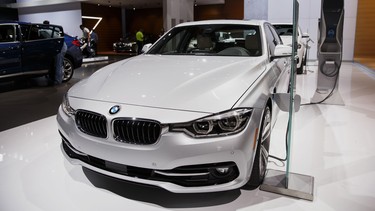 The BMW 330e sedan sits at a charging station during the Los Angeles Auto Show.