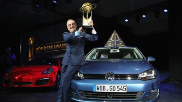 Volkswagen design chief Walter de Silva hoists a trophy into the air after the Volkswagen Golf was named the 2013 World Car of the Year at the New York Auto Show. He will be retiring from his post with the automaker in November.