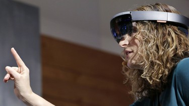 In this Jan. 21, 2015 photo, Microsoft's Lorraine Bardeen demonstrates HoloLens headset during an event at the company's headquarters in Redmond, Wash. With the new HoloLens headset, Microsoft is offering real-world examples to show how you might use three-dimensional digital images - or holograms - in daily life.
