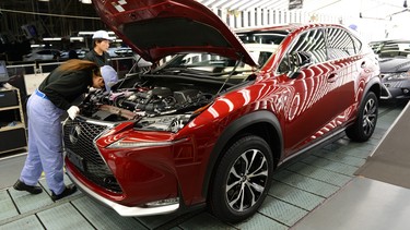 Employees of Toyota Motor's subsidiary Toyota Motor Kyushu check Lexus vehicles on an assembly line at the Miyata Plant in Miyawaka, Fukuoka Prefecture, on August 8, 2014.