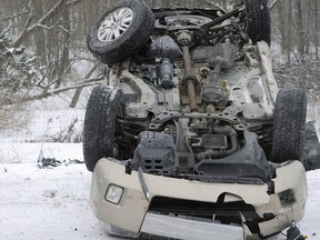 Carrie Miller, 25, looks at her wrecked, overturned vehicle following a 25-vehicle chain-reaction crash on Interstate 79 just north of Edinboro, Pa., on Thursday, Feb. 27, 2014, at about 9 a.m. in Franklin Township. Miller said white-out conditions caused by a heavy snow squall caused the accident.
