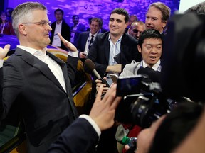 Michael Horn, left, President and CEO of Volkswagen Group of America, talks to the media at the Los Angeles Auto Show on Wednesday, Nov. 18, 2015, in Los Angeles.