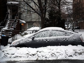 A snow covered car sits along a road on February 18, 2014 in Brooklyn area of New York City. Prepare the right way and winter's bite won't be that harsh.