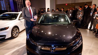 John W. Mendel, executive vice president of American Honda Motor Co., Inc., poses with the Honda Civic, winner of the North American Car of the Year award in Detroit, Monday, Jan. 11, 2016.