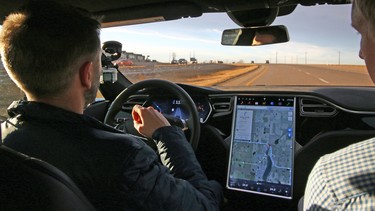 Calgary Herald writer Tom Babin lets the autopilot drive the Tesla Model S P90D electric car east of Calgary on Thursday, Nov. 12, 2015.