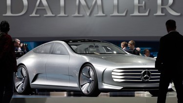 In this April 6, 2016 file photo visitors look at a Mercedes Benz concept car prior to the shareholders meeting of the Daimler AG in Berlin, Germany.