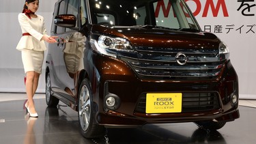 This file picture taken on February 13, 2014 shows a model presenting the all-new Nissan DAYZ-ROOX at the showroom headquarters of Nissan motor in Yokohama, suburb of Tokyo.  Japanese automaker Mitsubishi on April 20, 2016 admitted it falsified fuel-efficiency tests in more than 600,000 vehicles, after reports of misconduct sent its Tokyo-listed shares crashing. The problem affected vehicles including mini-cars "eK Wagon" and "eK Space", and the "Dayz" and "Dayz Roox", which Mitsubishi produces for rival Nissan.