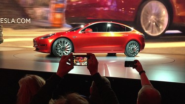 Tesla Motors unveils the new lower-priced Model 3 sedan at the Tesla Motors design studio in Hawthorne, Calif., Thursday, March 31, 2016. It doesn't go on sale until late 2017, but in the first 24 hours that order banks were open, Tesla said it had more than 115,000 reservations. Long lines at Tesla stores, reminiscent of the crowds at Apple stores for early models of the iPhone, were reported from Hong Kong to Austin, Texas, to Washington, D.C. Buyers put down a $1,000 deposit to reserve the car.