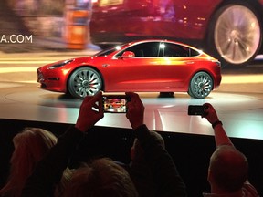 Tesla Motors unveils the new lower-priced Model 3 sedan at the Tesla Motors design studio in Hawthorne, Calif., Thursday, March 31, 2016. It doesn't go on sale until late 2017, but in the first 24 hours that order banks were open, Tesla said it had more than 115,000 reservations. Long lines at Tesla stores, reminiscent of the crowds at Apple stores for early models of the iPhone, were reported from Hong Kong to Austin, Texas, to Washington, D.C. Buyers put down a $1,000 deposit to reserve the car.