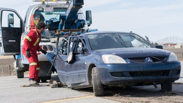 A tow truck clears wreckage from a collision southbound on the QEII highway just north of Airdrie, Alta., on Sunday, April 3, 2016.