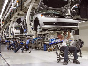 In this July 12, 2013, file photo, employees at the Volkswagen plant in Chattanooga, Tenn., work on the assembly of Passat sedans.