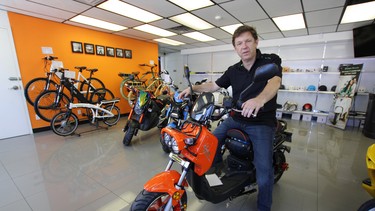 Motorino EV owner Steve Miloshev aboard his shop’s top-selling electric scooter, the XPd, in the 2nd Avenue showroom in Vancouver.