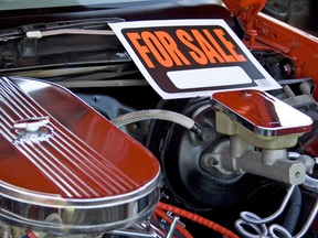 For sale sign inside of a car engine at a car show.