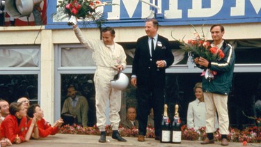 From left, Bruce McLaren, Henry Ford II and Chris Amon on the victory podium of the 1966 24 Hours of Le Mans.