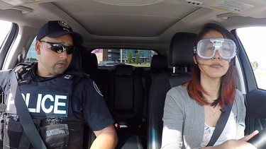 Constable Ryan Willmer of the Toronto Police rides along while Emily Chung tests the "drunk googles" during Ford's Driving Skills for Life event for young drivers
