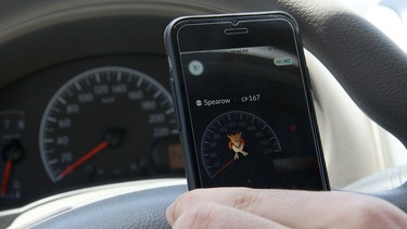 A gamer uses the Pokemon Go application on his mobile in his car.