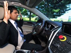 Raj Rajkumar, professor of engineering at Carnegie Mellon University, drives the autonomous vehicle down Schenley Drive in Schenley Park in Pittsburgh, on June 1, 2016. The university has been working on a self-driving vehicle for nearly three decades, but the effort kicked into high gear in February 2015 when Uber announced it would partner with CMU's National Robotics Engineering Center.