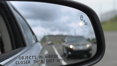 A side mirror warning signal in a Ford Taurus.