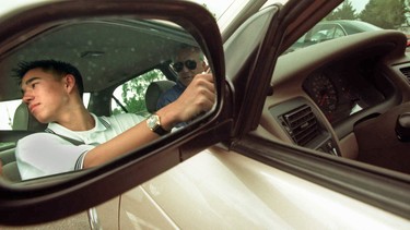 Tyler Ichien, 15, of Los Gatos, California, looks over his shoulder before backing out of the Leigh High School Parking lot to resume his drivers education course with teacher Frank Hendricks.