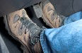 A driver wearing hiking boots 'rides the clutch' by stepping on the gas and clutch pedals at the same time.