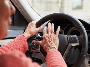 In car view of senior female driver using the horn