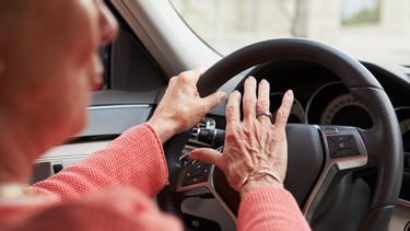 In car view of senior female driver using the horn