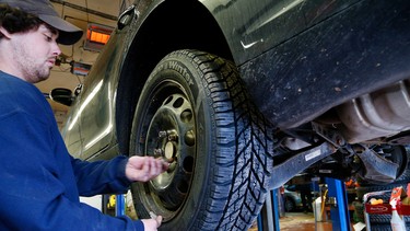 Worker Nate Davis installs a winter tire at Curry Tire in Peterborough.