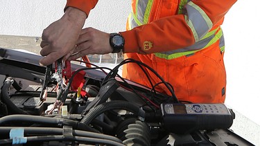 A CAA Manitoba technician prepares to boost a battery at a member's home in West Kildonan.