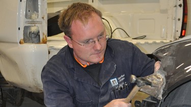 Jason Budd, auto body teacher at the Calgary Board of Education's Career & Technology Centre, works out a dent using a hammer and dolly. Budd and his co-worker Francesco Fulginiti are offering evening classes on automotive detailing through Chinook Learning Services' Continuing Education program.