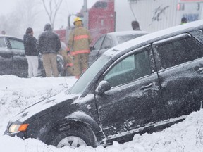 Lindsay firefighters and paramedics work after a four-vehicle collision involving a combination grain truck on Hwy. 7 just east of Kawartha Lakes Rd. 36 southeast of Lindsay that happened shortly after 9 a.m. during snowy conditions on Thursday, December 15, 2016 west of Peterborough, Ont.