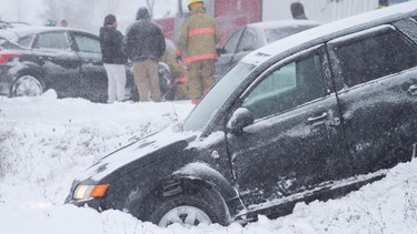 Lindsay firefighters and paramedics work after a four-vehicle collision involving a combination grain truck on Hwy. 7 just east of Kawartha Lakes Rd. 36 southeast of Lindsay that happened shortly after 9 a.m. during snowy conditions on Thursday, December 15, 2016 west of Peterborough, Ont.