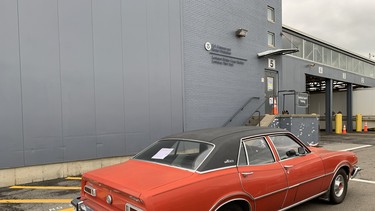 A red 1974 Ford Maverick waits outside the US Customs facility during the export process