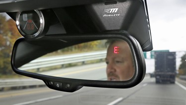 A Mobileye camera system that can be installed in your car to monitor speed limits and warn drivers of potential collisions, mounted behind the rearview mirror.