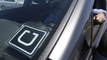 In this July 15, 2015, file photo, Uber driver Karim Amrani sits in his car parked near the San Francisco International Airport parking area in San Francisco.