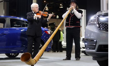 William Hopson of the Calgary Philharmonic plays an alp horn alongside roving violinist Igor Motchalov among the cars and trucks at last year's Vehicles and Violins Gala.