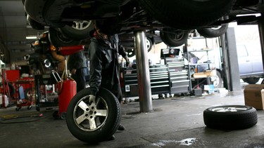 A mechanic prepares to install a tire on a Dodge Caravan.