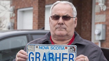 Lorne Grabher displays his personalized licence plate in Dartmouth, N.S. The controversy over Lorne Grabher's licence plate, which reads "GRABHER", could be settled in court after the Nova Scotia government refused a request from a group of lawyers to allow Grabher to resume using the now-banned plate.