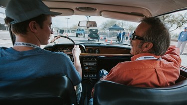Patrick Bryson instructing a young driver in his 1967 BMW 200CS.