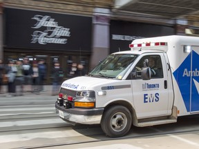 An ambulance races across Queen Street at the Eaton Centre in Toronto.