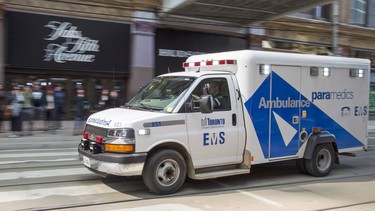 An ambulance races across Queen Street at the Eaton Centre in Toronto.