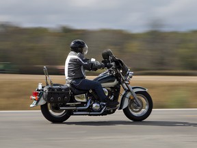 A motorcyclist cruises along Highway 24 north of Simcoe, Ontario on Friday October 13, 2017. Ontario Provincial Police say an estimated 110,000 people attended the traditional Friday the 13th Gathering of motorcyclists at the small Lake Erie port town of Port Dover.