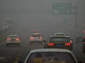 Commuters drive on a road in heavy pollution in Beijing.