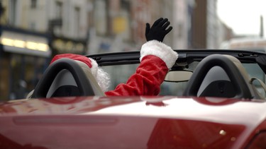 Santa waiving from his red deliviery car