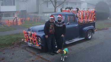 Jordan and Carol McRae with Lady the beagle and their candy cane pickup truck in front of their ‘excessively decorated’ Surrey home.