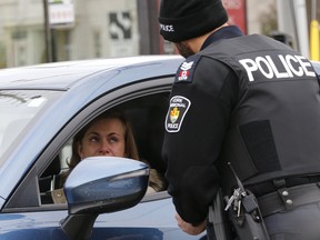 Sgt. Clint Whitney with a driver after she was pulled over, as part of a new distracted driving program that nabbed drivers in Richmond Hill, Ontario, for the media on Wednesday on Wednesday November 22, 2017.