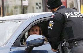 Sgt. Clint Whitney with a driver after she was pulled over, as part of a new distracted driving program that nabbed drivers in Richmond Hill, Ontario, for the media on Wednesday on Wednesday November 22, 2017.