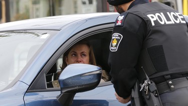 Sgt. Clint Whitney with a driver after she was pulled over, as part of a new distracted driving program that nabbed drivers in Richmond Hill, Ontario, for the media on Wednesday on Wednesday November 22, 2017.